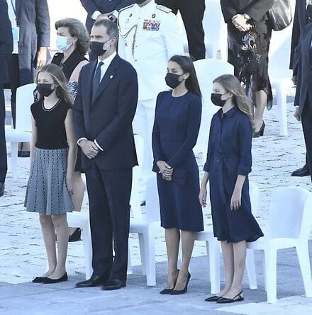 Letizia wears a navy blue dress by Carolina Herrera, Nina Ricci shoes and carries a clutch by Magrit. Princess Leonor and Infanta Sofia