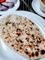 Serving garlic butter naan in a plate, dal in background