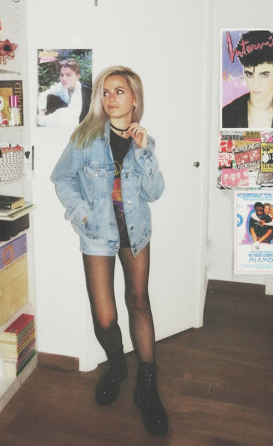 Estilo grunge con camiseta negra ancha con imagen del grupo The Doors, pantalón corto, medias de red pequeña, botas estilo militar y cazadora vaquera