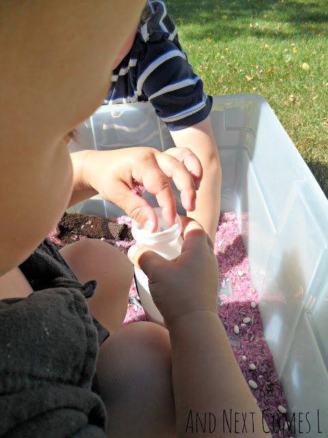 Toddler playing with colored rice as part of a Gruffalo activity