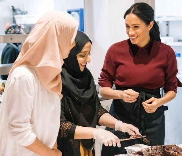 Meghan Markle wore Club Monaco burgundy Daylina coat and Club Monaco Sallyet dress. Givenchy GV3 black ankle boots. Birks gold bar earrings