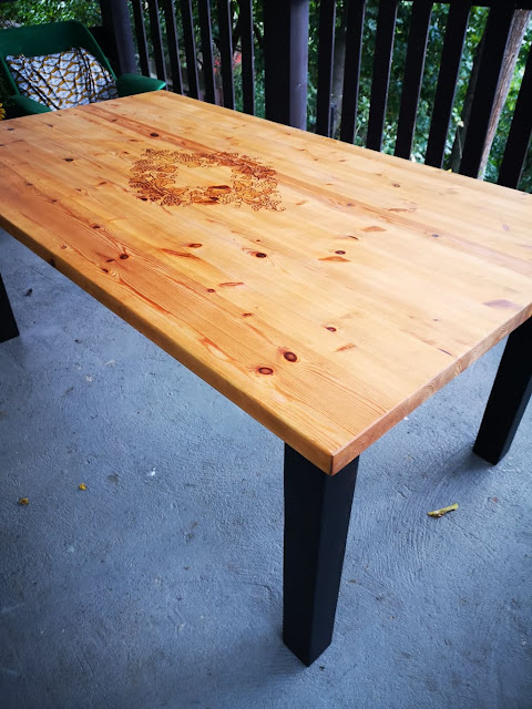 odnowiony duży stół z litego drewna z czarnymi nogami i z motywem winogron
