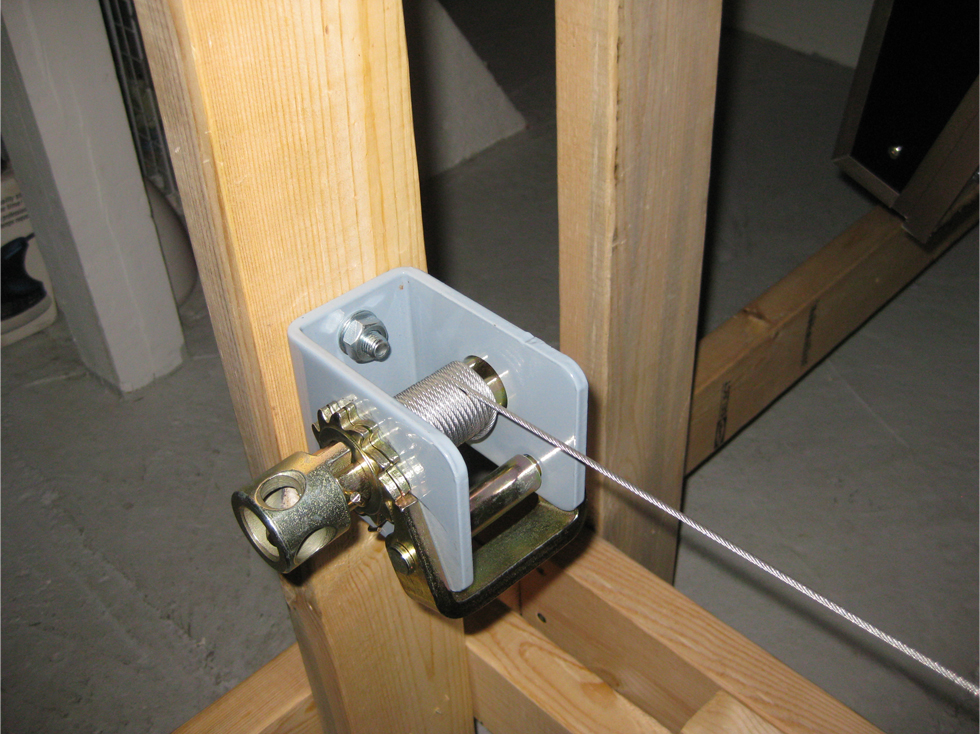 Locking winch with steel aircraft cable bolted to a 2 x 4 wooden support leg on model railroad benchwork