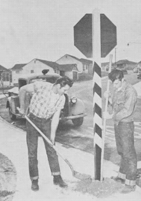 A photograph showing a black-and-white stop sign being installed.