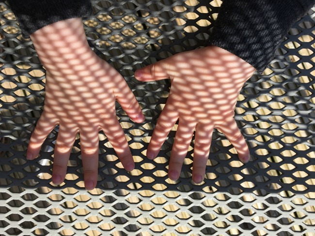 toddler hands with shadows making patterns on them