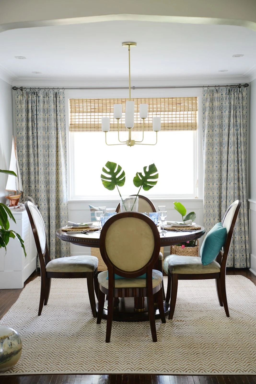 Rambling Renovators | tropical dining room, round dining table, Hinkley Harlow chandelier, tonic living naga blue curtains