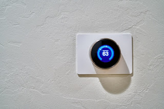 Thermostat hanging against a white wall