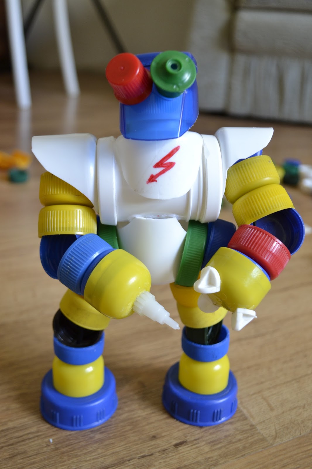 робот из пластиковых крышек. игрушки из крышек от пластиковых бутылок. робот из пластиковых крышек. поделка робот из крышек.