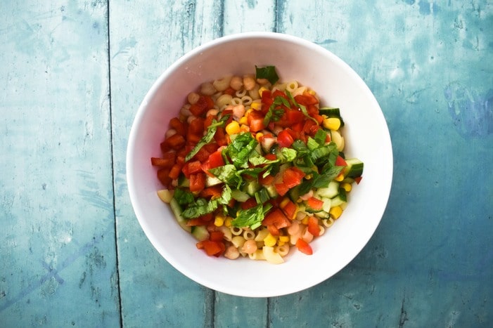 Vegan macaroni salad -Step 4 (pasta and fresh basil added to the bowl)