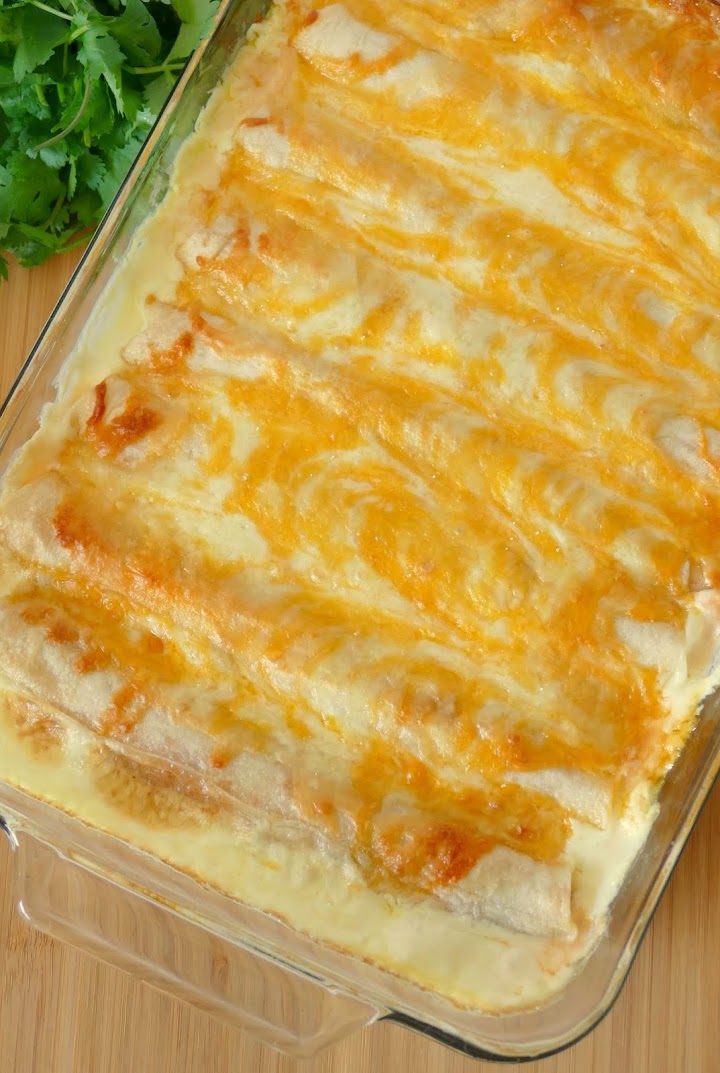 These chicken enchiladas are full of creamy, cheesy goodness! Perfect for Sunday dinner and sure to be a new family favorite! Use rotisserie chicken to save time in the kitchen!