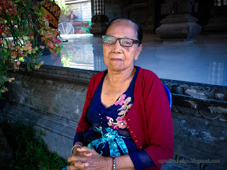 Grandmother Sitting In Front Of Wantilan Traditional Balinese Pavilion Building In The Middle Of The Temple Ringdikit North Bali Indonesia