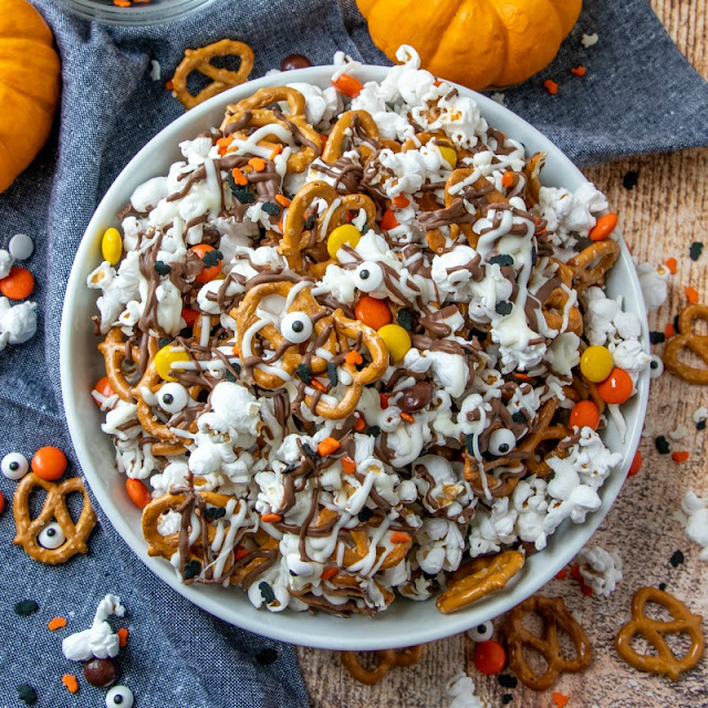 Bowl filled with candy, popcorn, pretzels and covered in chocolate