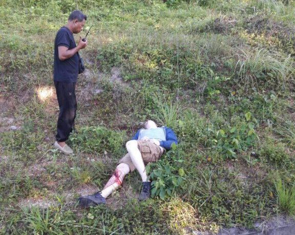 Таец говорит по рации возле пострадавшего