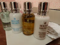 four molton brown products lined up in bathroom