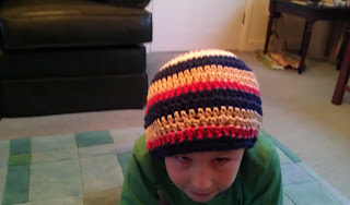 boy keeping head warm with a crocheted woolly hat stripes