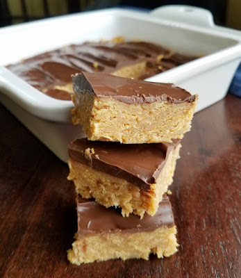 If a quick and easy chocolate peanut butter treat is what you meed, these corn flake bars are just the thing. They are the perfect mix of crunchy, chewy and delicious. large pieces of no bake chocolate peanut butter corn flake bars in front of pan of bars