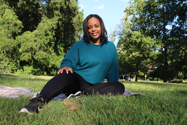 Woman in a field sitting on a yoga mat