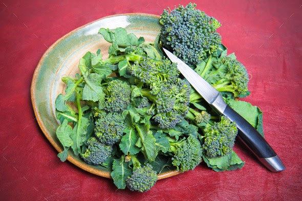 Plate with raw sicilian broccoli and knife