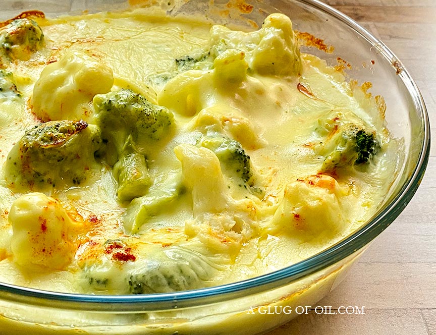 Homemade cauliflower and broccoli cheese, pictured in a glass dish.