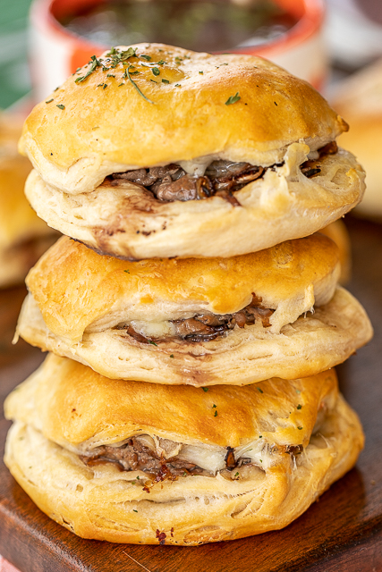 French Dip Biscuits Recipe - refrigerated biscuits, stuffed with roast beef, provolone, horseradish, and baked. Brush with melted butter when they are hot. Serve with a side of hot au jus. SO good! Great for parties, tailgating, lunch or dinner. These are always a hit! #sandwich #roastbeef #frenchdip #biscuit stack of 3 biscuits