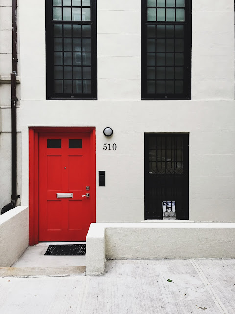 House with red door and black window frames: Photo by Jon Tyson on Unsplash
