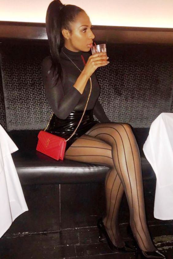 Beautiful woman wearing black mini skirt, black tights and black pumps high heels