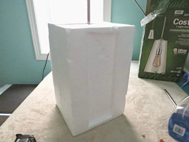 securing the light fixture with the foam from inside the box