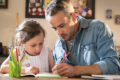 a dad helping his daughter with her homework