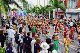 Hawaiian hula dancers and ukulele players marching