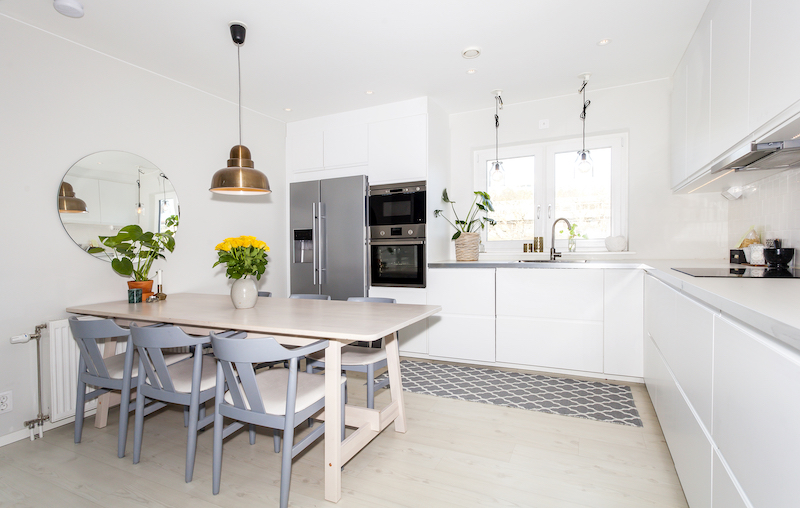 Ideas para aprovechar el espacio en la cocina: Cocina con zona de office y gran espejo en la pared