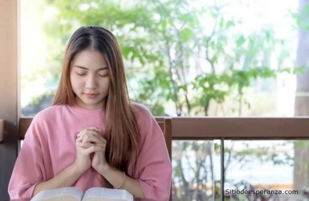 Mujer orando con Biblia