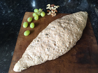 A fat batard proving on the the tray with some artistic but pointless grapes and nuts