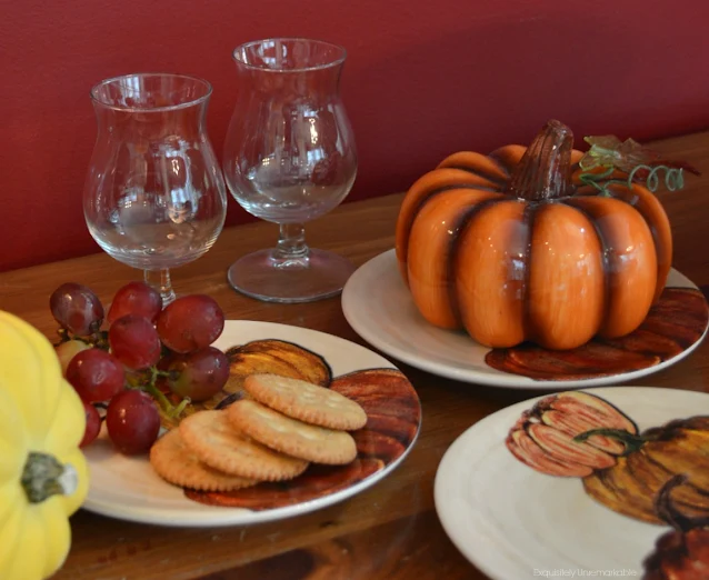 Pumpkin plates with fruit and crackers on a table