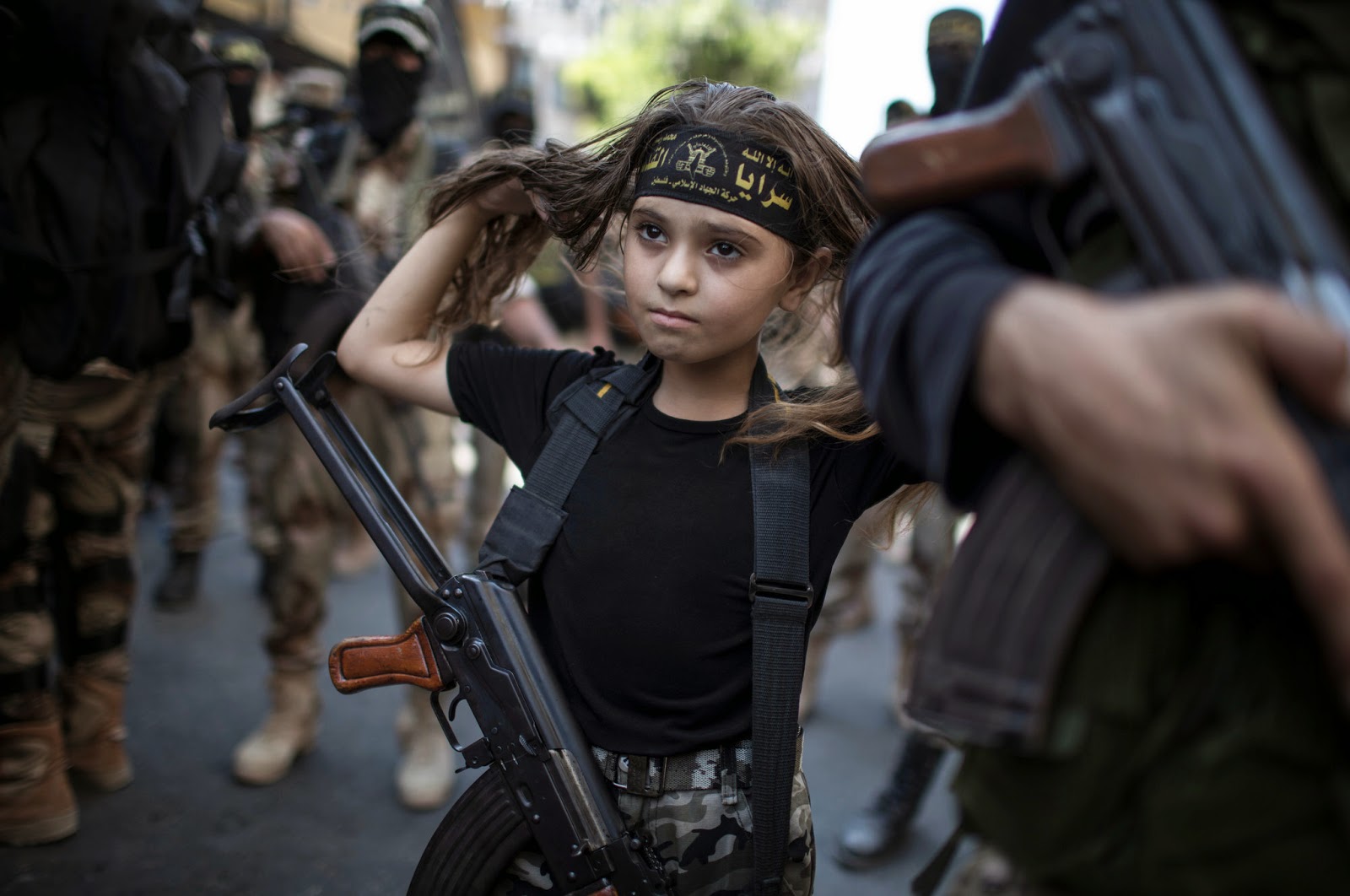 A PALESTINIAN GIRL WITH A KALASHNIKOV RIFLE, AMID MILITANTS IN GAZA CITY - 29 Breathtaking Photographs of The Human Race