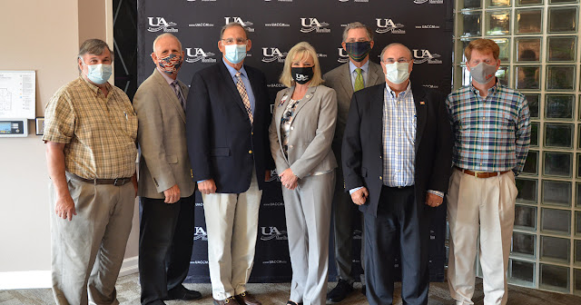 Group of people standing in front of a UACCM backdrop