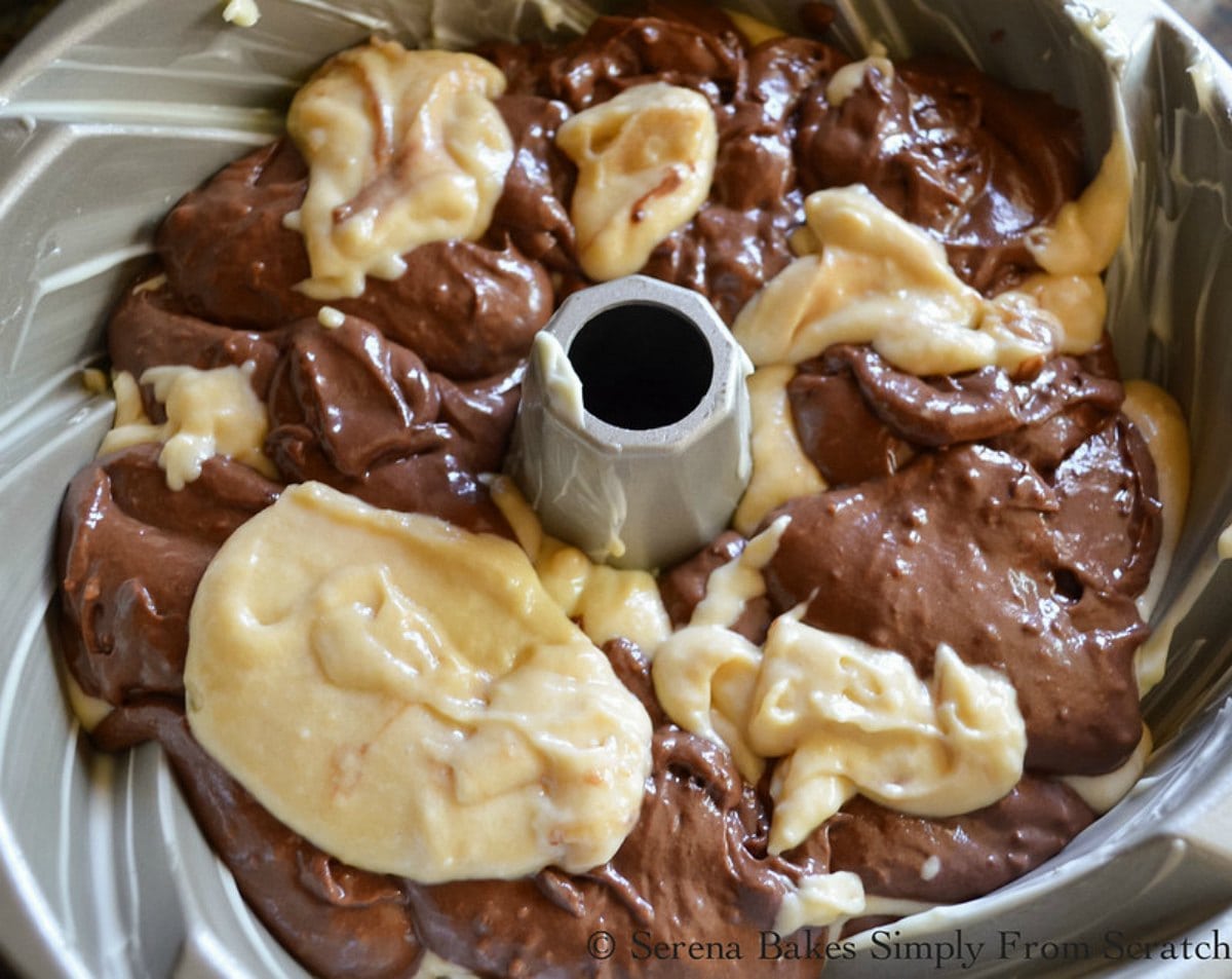 Layers of chocolate and buttermilk cake batter in a swirl bundt pan.