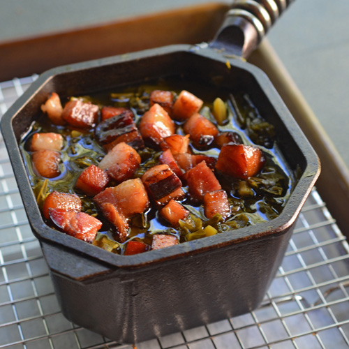 Collard greens with homemade bacon in a Finex cast-iron pot