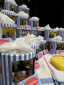 Display of Reckitt's bags containing miniature vintage laundries.