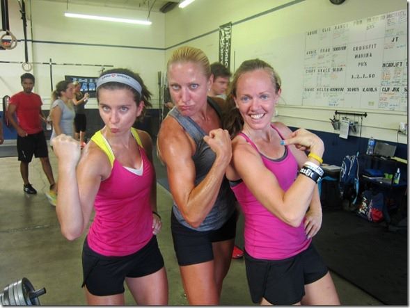 three female fitfluential bloggers posing for a photo and flexing their biceps after a CrossFit workout