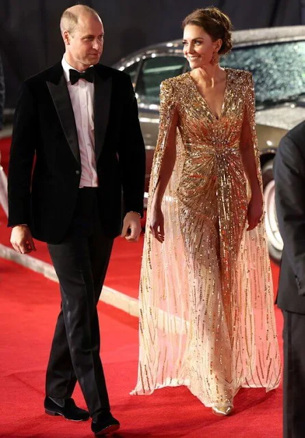 Kate Middleton wore a shimmering cape gown by Jenny Packham. Gold earrings. Aquazzura Fenix gold metallic leather pumps