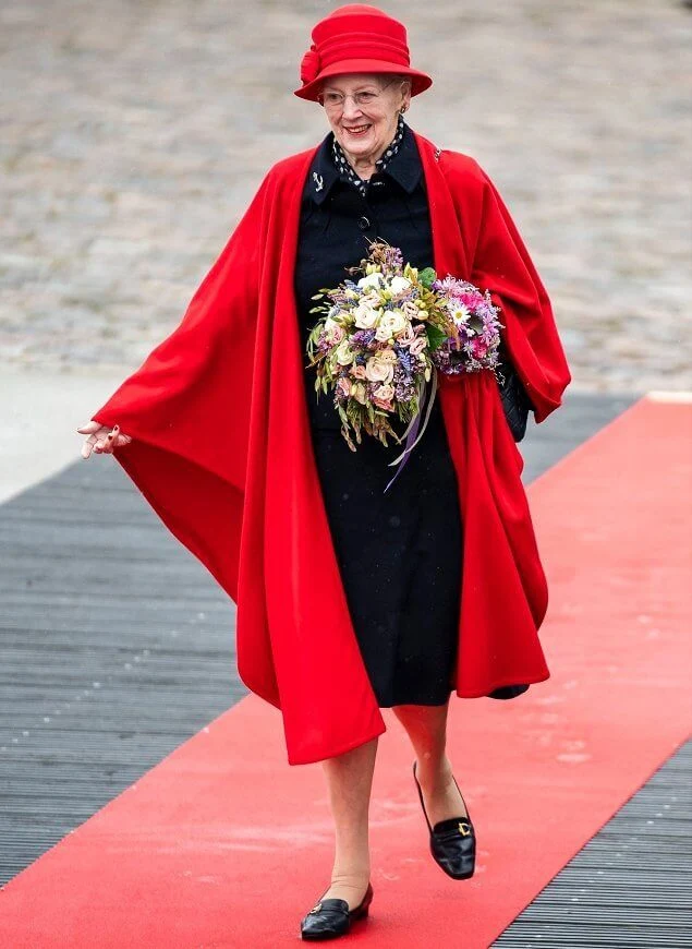 Queen Margrethe wore a red wool cape and hat. Crown Princess Mary