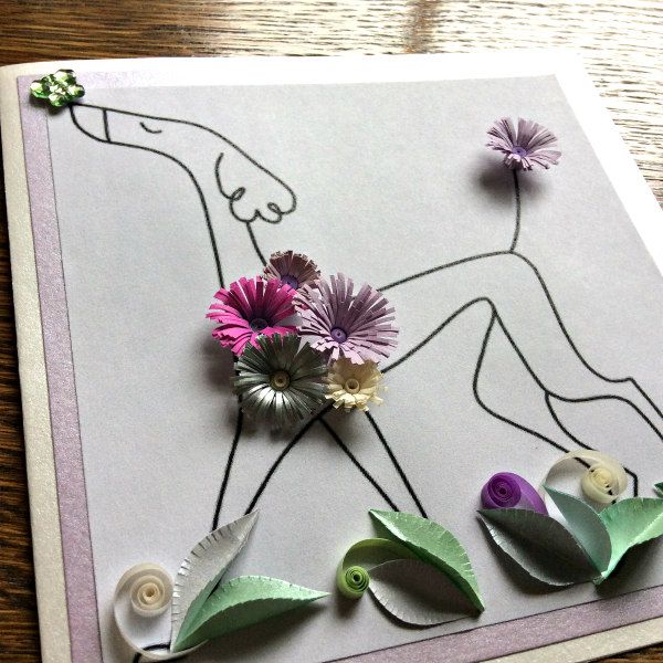greeting card with dog decorated with quilled fringed flowers, leaves, and a butterfly balanced on nose