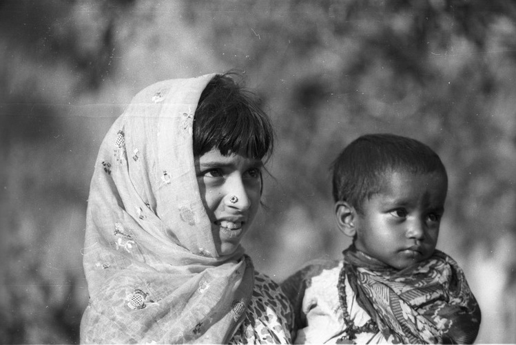 Young girl from Afghanistan carrying a small Hindu child from the ...