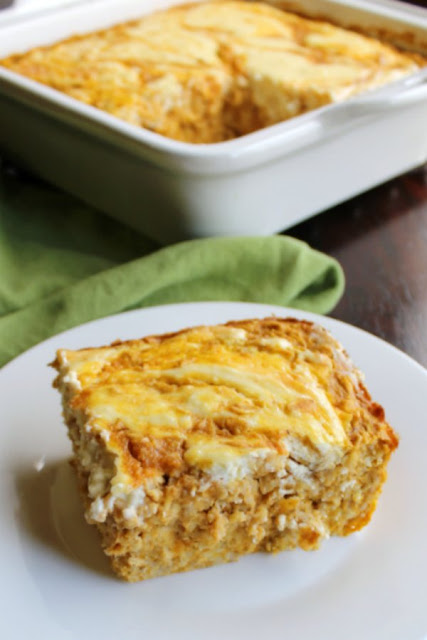 Soft and delicious pumpkin baked oatmeal with a maple cream cheese swirl. This is a hearty fall breakfast that is packed with the good stuff and will remind you of your favorite pumpkin roll cake. piece of pumpkin roll baked oatmeal served on plate with remaining oatmeal in pan in the background