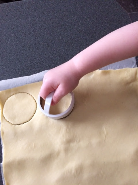 Child using a pastry cutter to cut pastry