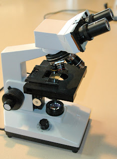 A black and white microscope on a desk.