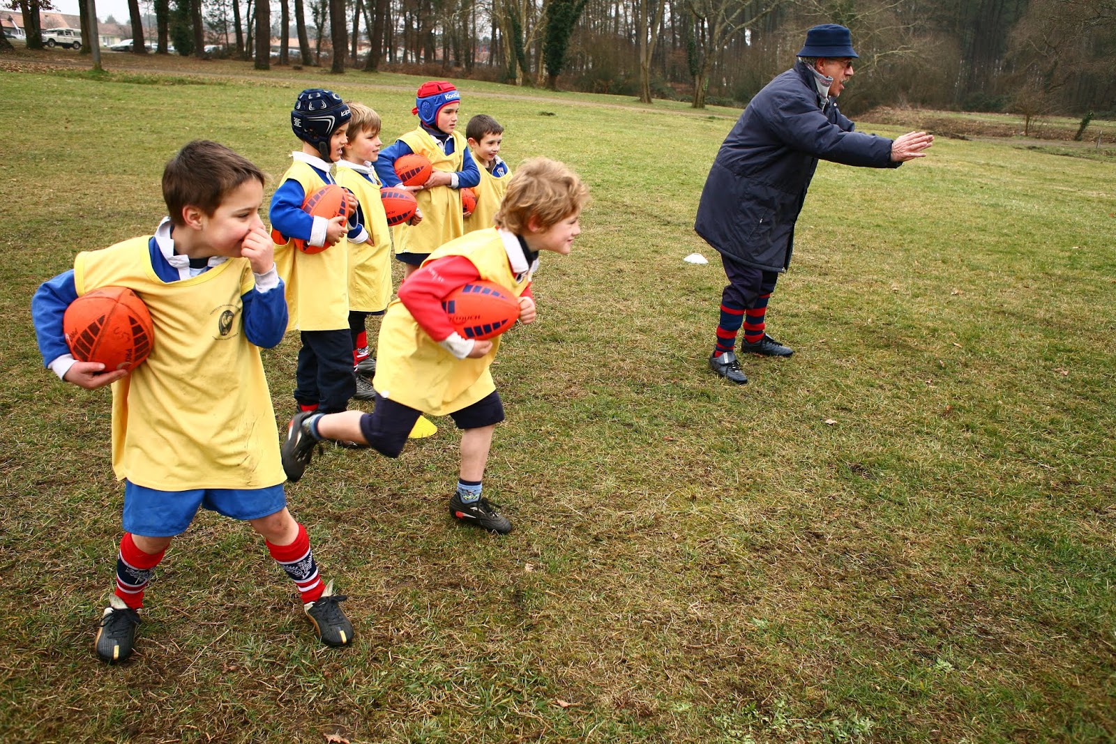 Un Tableau D'enfants Courant Avec Un Ballon De Rugby.
