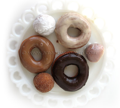 An overhead photo of a plate of an assortment of homemade doughnuts.