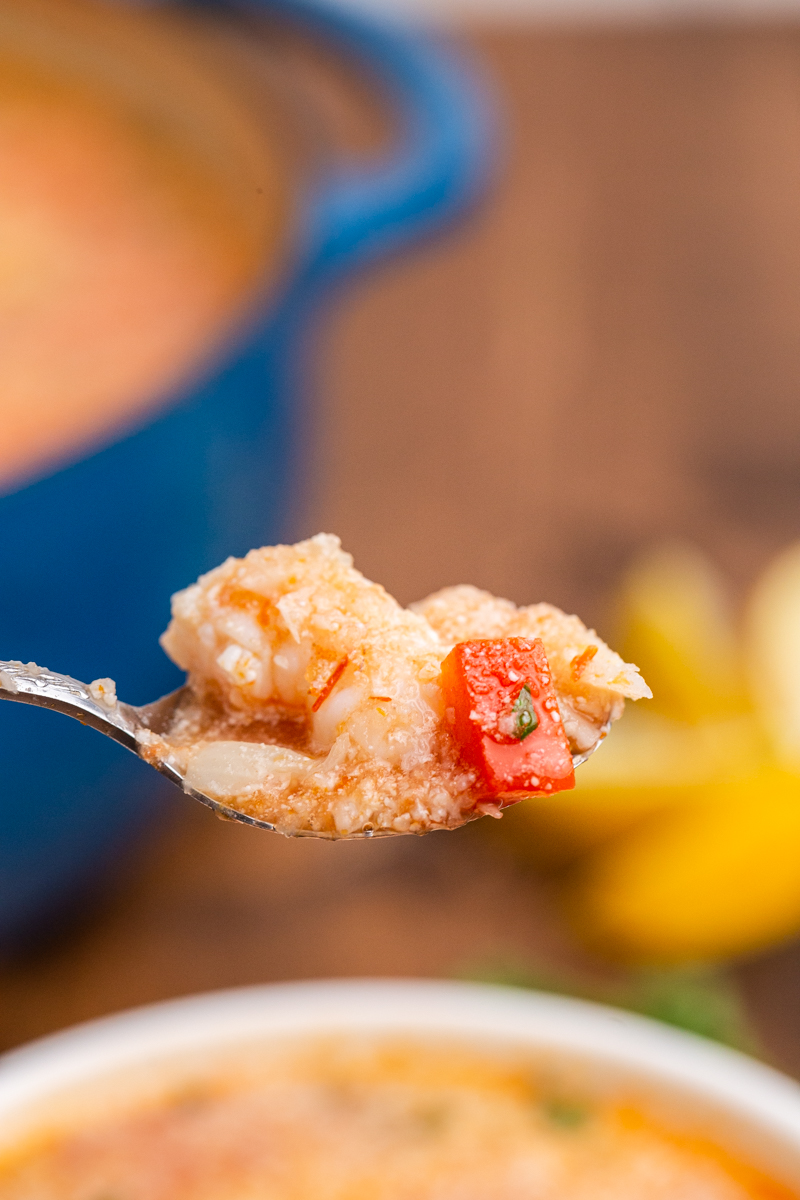 Closeup photo of a spoonful of Keto Brazilian Shrimp Stew over a white bowl.