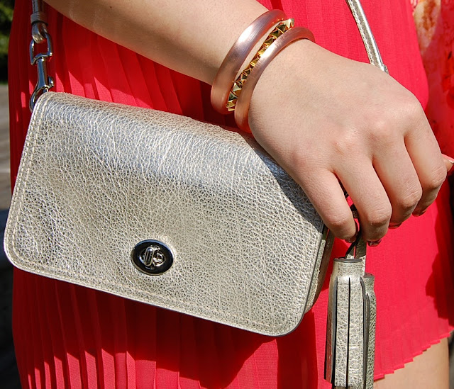 Gold Coach bag, Eddie Borgo pyramid bracelet and Alexis Bittar bangles